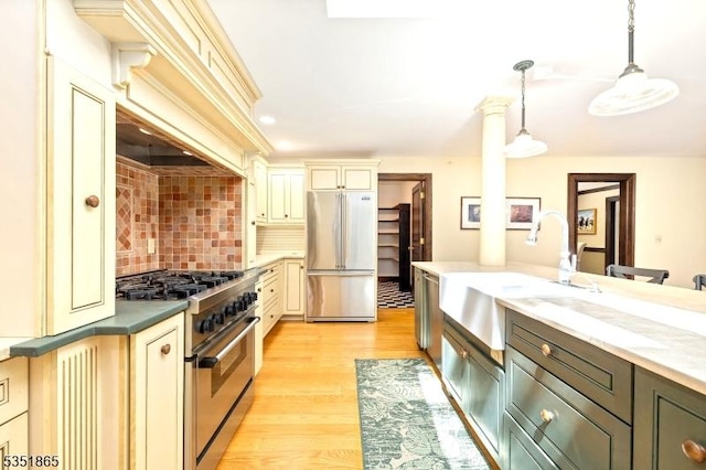 70 Friar Ln, Watchung Boro, NJ 07069 - kitchen featuring premium appliances, cream cabinetry, a sink, decorative light fixtures, and decorative backsplash