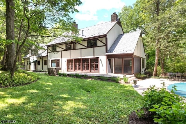 70 Friar Ln, Watchung Boro, NJ 07069 - back of house with stucco siding, a sunroom, a lawn, and a chimney