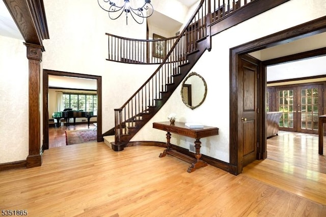 70 Friar Ln, Watchung Boro, NJ 07069 - stairs featuring wood finished floors, french doors, a chandelier, baseboards, and a high ceiling