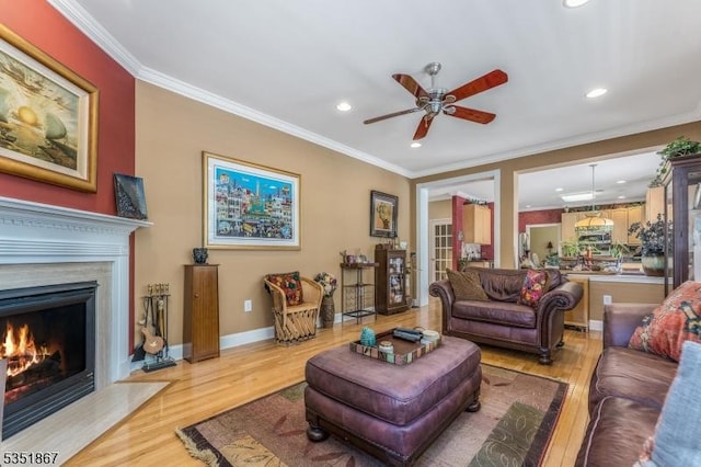 living area featuring a fireplace, ceiling fan, light wood finished floors, and recessed lighting