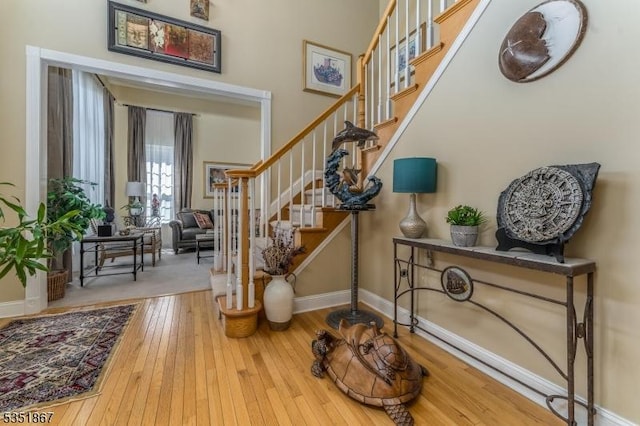 foyer with stairway, baseboards, and hardwood / wood-style flooring