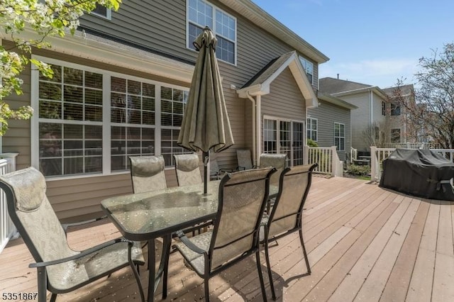 wooden terrace with outdoor dining space and grilling area
