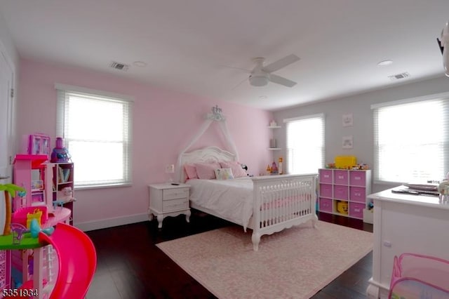 bedroom with a ceiling fan, visible vents, and dark wood finished floors