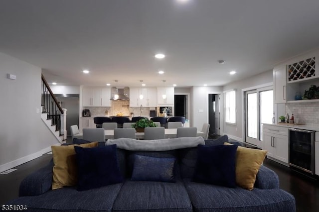 living room featuring recessed lighting, baseboards, a bar, and stairs