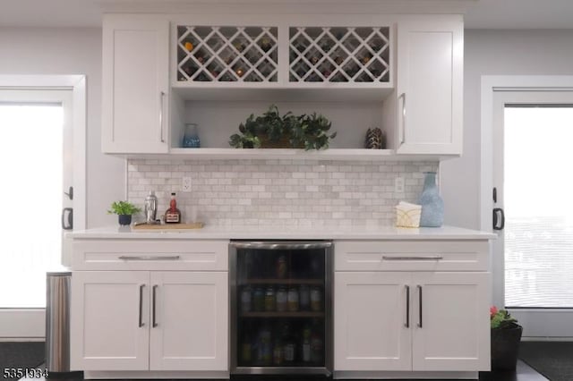 bar with a bar, decorative backsplash, and wine cooler