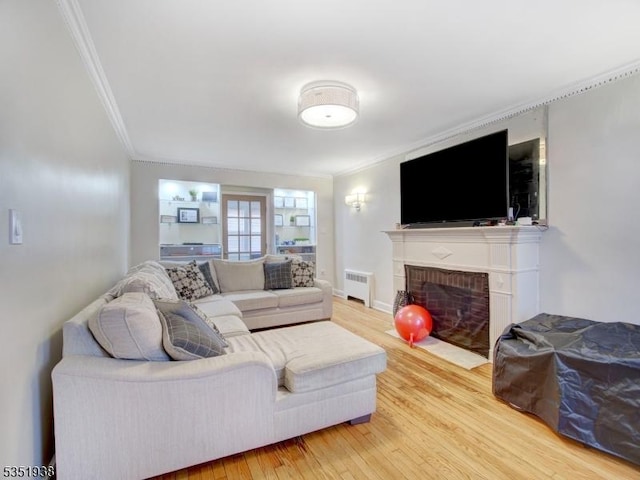 329 Hobson St, Newark City, NJ 07112 - living area with radiator heating unit, ornamental molding, wood finished floors, and a brick fireplace