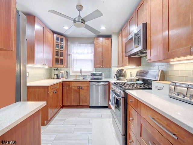 329 Hobson St, Newark City, NJ 07112 - kitchen featuring stainless steel appliances, a sink, tasteful backsplash, a ceiling fan, and glass insert cabinets