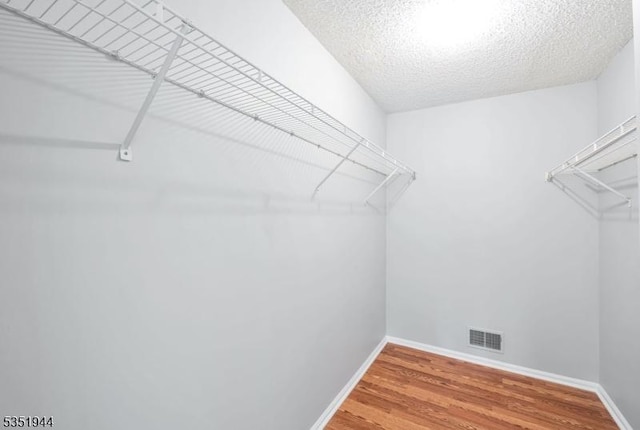 walk in closet featuring wood finished floors and visible vents