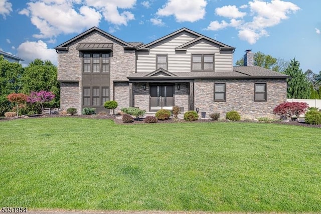 view of front of house with a chimney, a front yard, and stone siding