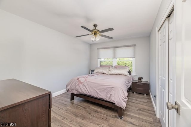 bedroom with baseboards, ceiling fan, a closet, and light wood-style flooring