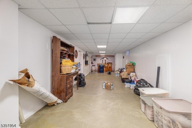 finished basement featuring baseboards and a paneled ceiling