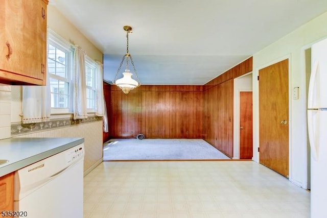 unfurnished dining area featuring wooden walls and light floors