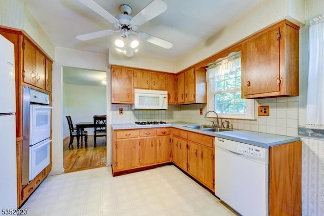 kitchen with white appliances, light floors, ceiling fan, light countertops, and a sink