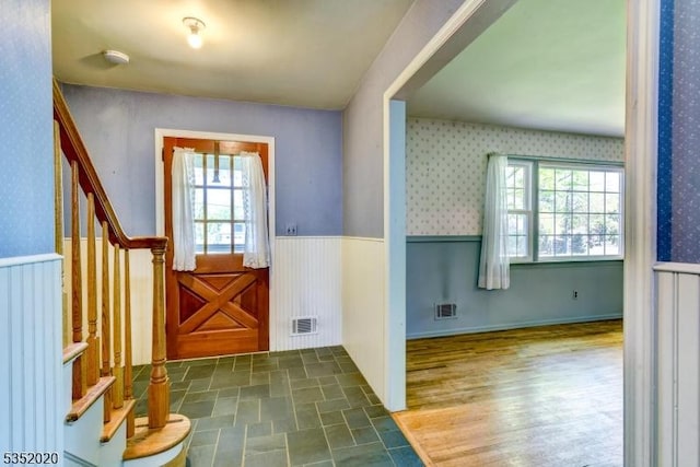 entryway featuring wallpapered walls, visible vents, wainscoting, and stairway