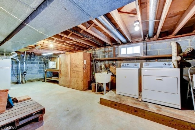 basement featuring washer and clothes dryer and a sink