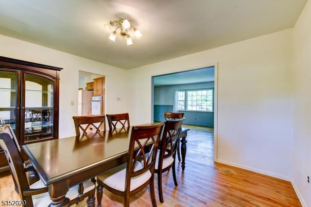 dining room featuring baseboards and light wood-style flooring