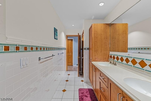 bathroom featuring double vanity, tile walls, tile patterned floors, and a sink