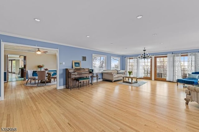 living room featuring baseboards, a wealth of natural light, crown molding, and light wood-type flooring