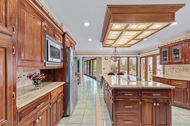 kitchen featuring french doors, decorative backsplash, appliances with stainless steel finishes, a kitchen island, and light tile patterned floors