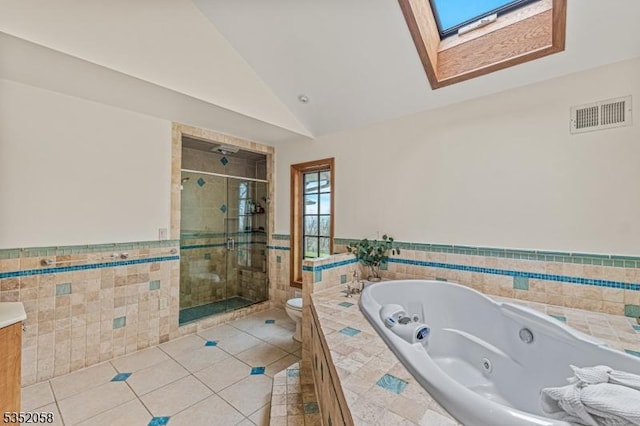 full bathroom featuring a shower stall, tile patterned floors, visible vents, tile walls, and wainscoting
