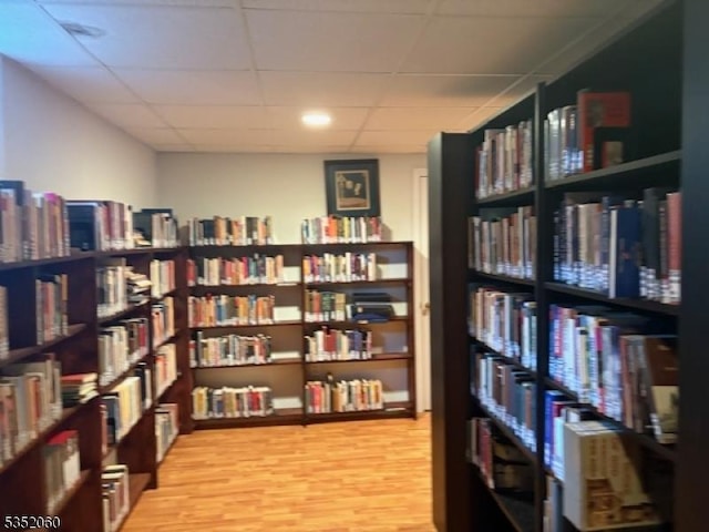 601 Buhler Ct, Pine Beach Boro, NJ 08741 - sitting room featuring wall of books, a drop ceiling, and light wood-type flooring
