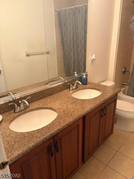 601 Buhler Ct, Pine Beach Boro, NJ 08741 - bathroom featuring toilet, double vanity, tile patterned flooring, and shower / tub combo with curtain