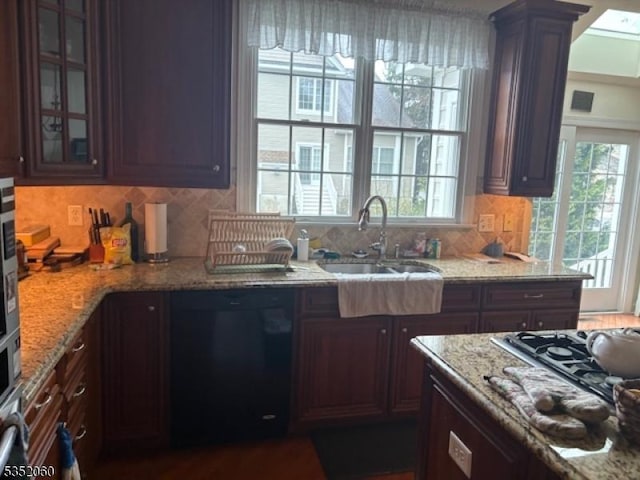 601 Buhler Ct, Pine Beach Boro, NJ 08741 - kitchen with black dishwasher, a sink, stainless steel gas cooktop, glass insert cabinets, and light stone counters