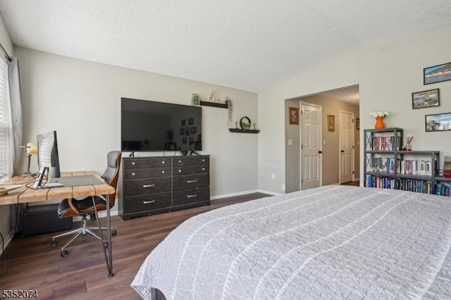 bedroom with baseboards, a textured ceiling, lofted ceiling, and wood finished floors