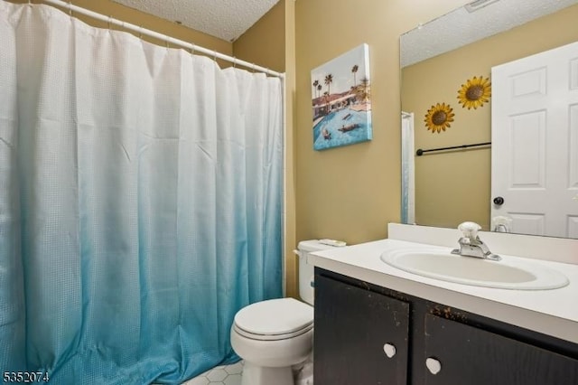 full bath featuring vanity, a textured ceiling, and toilet