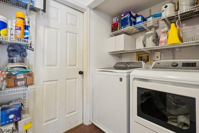 laundry area with laundry area, washer and clothes dryer, and dark wood-type flooring