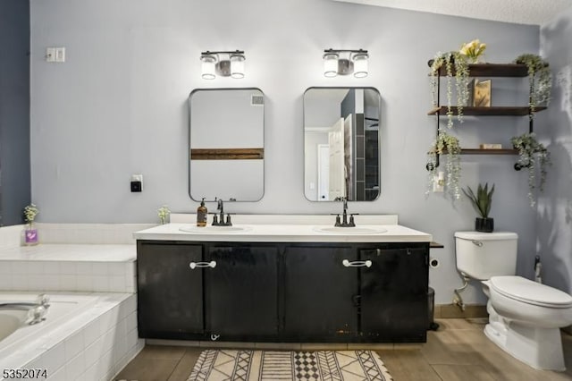 bathroom with double vanity, toilet, tiled bath, and a sink