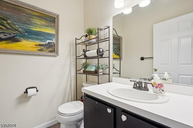 half bathroom featuring vanity and toilet