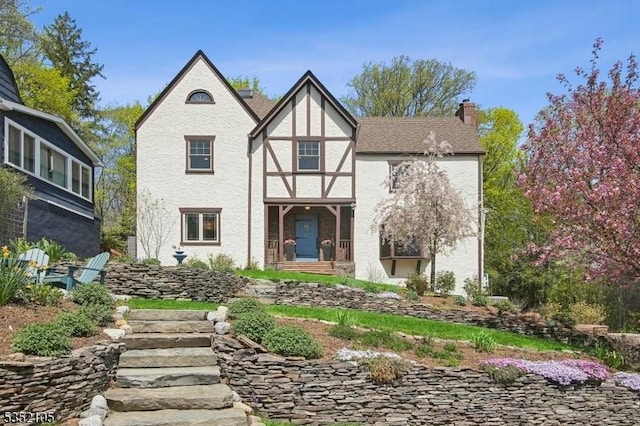 view of front of house with stucco siding and a chimney