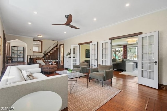 living room featuring a ceiling fan, ornamental molding, french doors, and wood finished floors