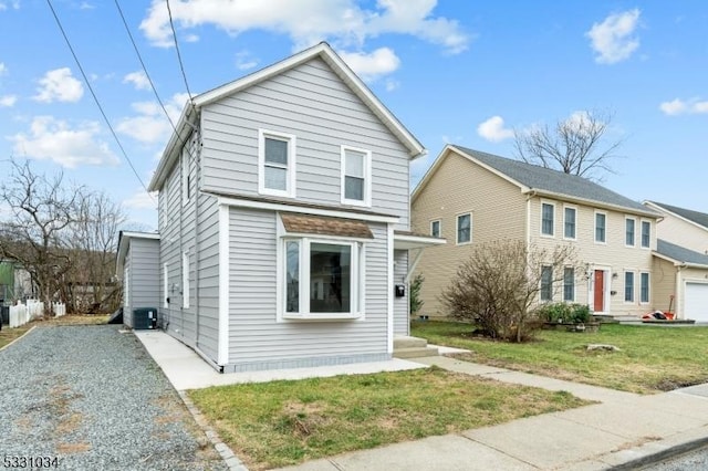 traditional home featuring a front lawn and central air condition unit