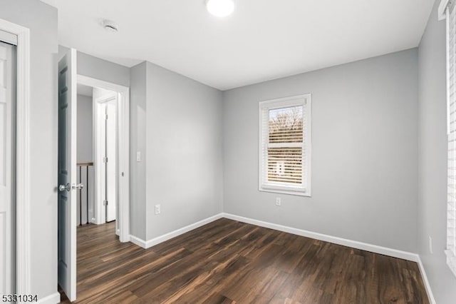 unfurnished bedroom featuring baseboards and dark wood finished floors
