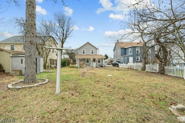 view of yard with an outdoor structure, a porch, a storage shed, and fence