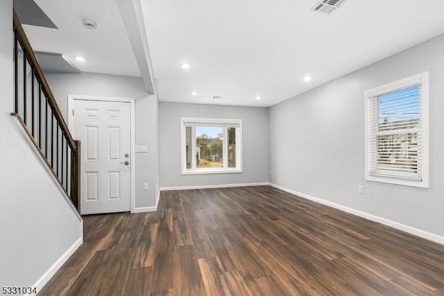interior space featuring plenty of natural light, baseboards, visible vents, and dark wood finished floors