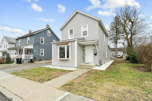traditional home featuring a chimney and a front lawn