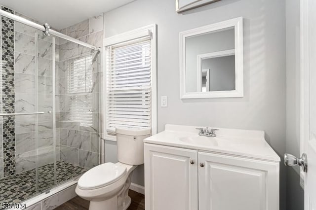 full bathroom with wood finished floors, vanity, toilet, and a stall shower