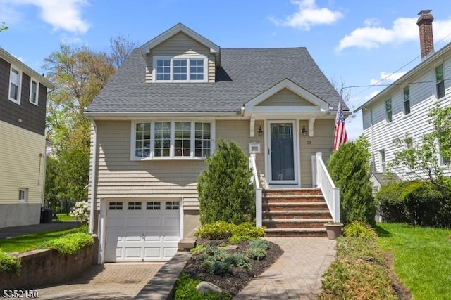 view of front facade featuring a shingled roof and a garage