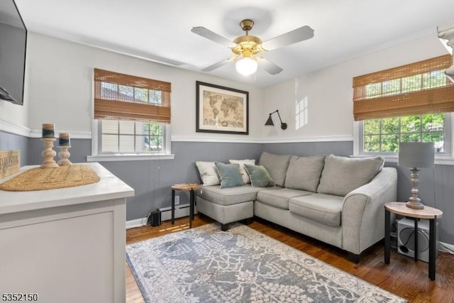 living room featuring a baseboard radiator, baseboards, ceiling fan, and wood finished floors