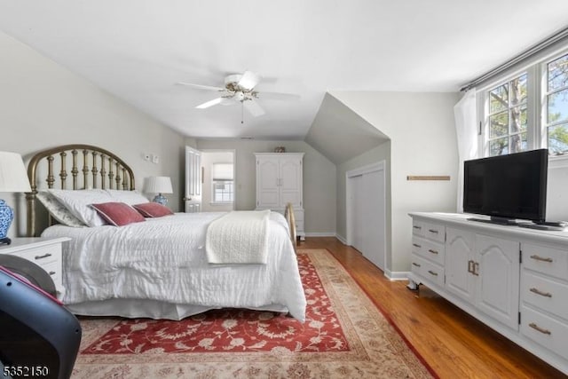 bedroom with light wood-type flooring, a ceiling fan, and baseboards
