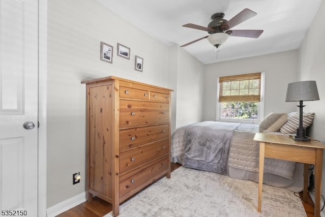 bedroom with baseboards, ceiling fan, and wood finished floors