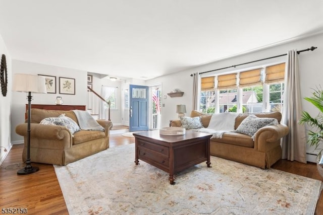 living area featuring wood finished floors and stairway