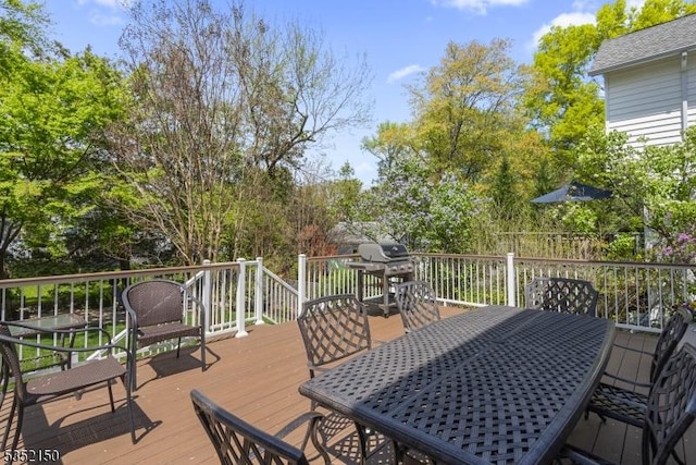 wooden deck with outdoor dining space and grilling area