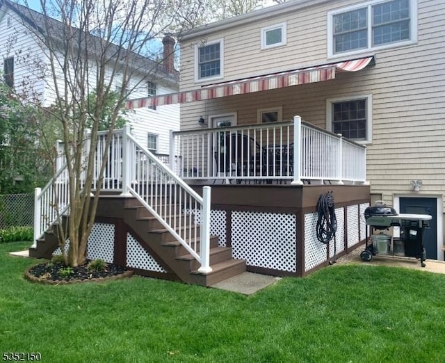 rear view of property with a lawn, a wooden deck, stairs, and a chimney