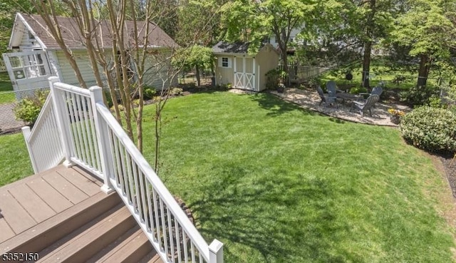 view of yard with a storage shed, fence, and an outbuilding