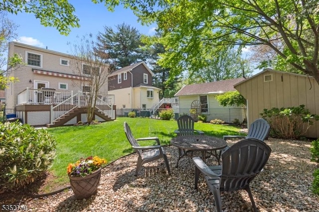 view of yard featuring stairs, an outdoor fire pit, and a deck