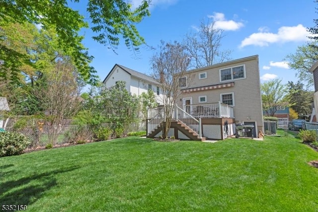 rear view of house featuring a yard, a deck, stairs, and a fenced backyard